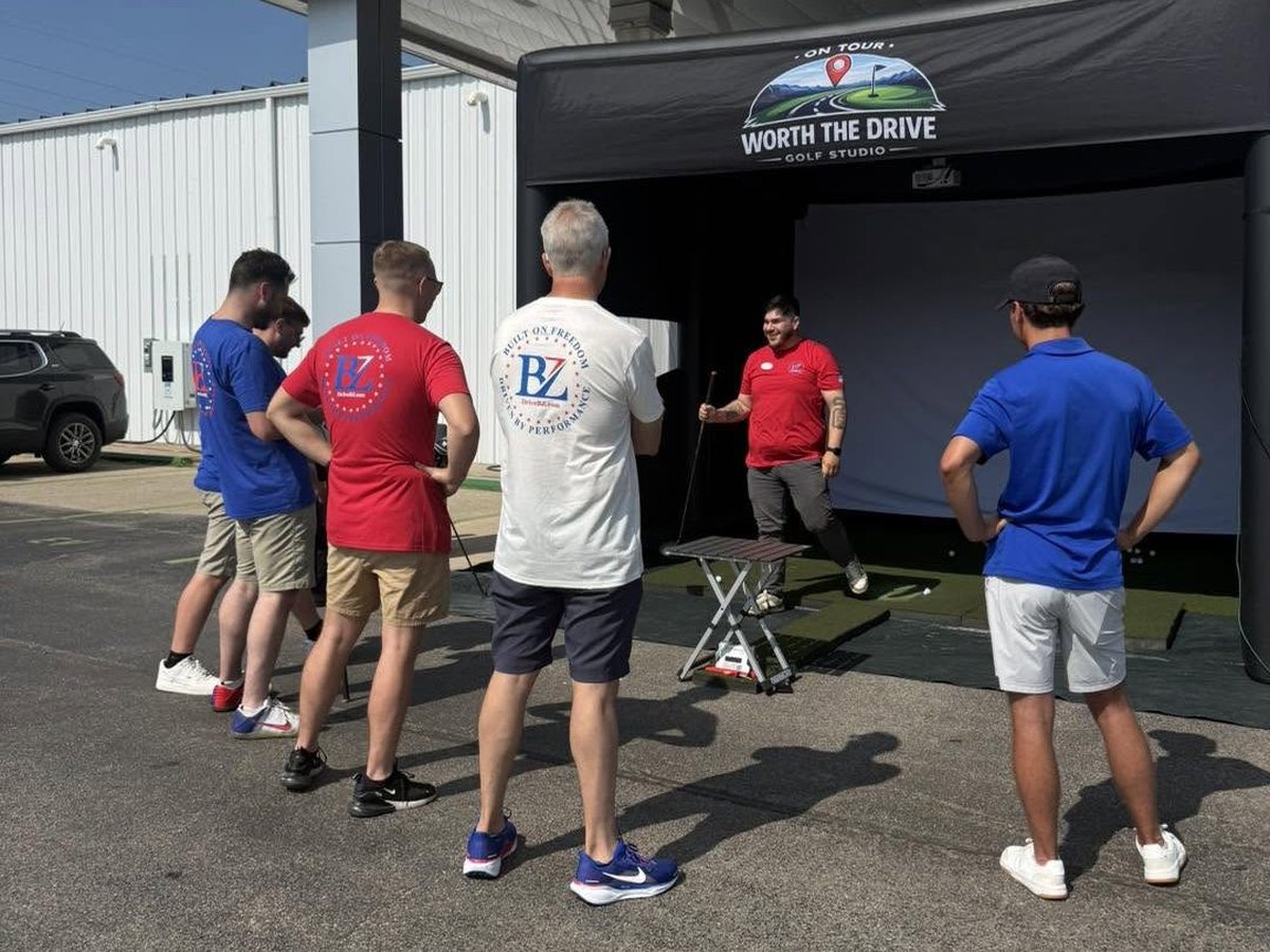 A company team taking turns on the simulator at a corporate event